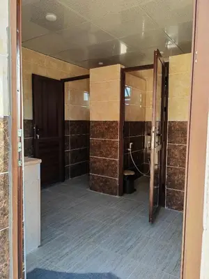 a bathroom with two sliding doors in a room at Namla Bedouin Camp in Umm Şawwānah