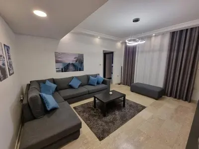 a living room with a couch and a table at Deir Ghbar 3 rooms apart in Amman