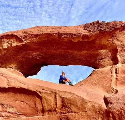 a man sitting on top of a rock formation at Wade rum natural in Wadi Rum