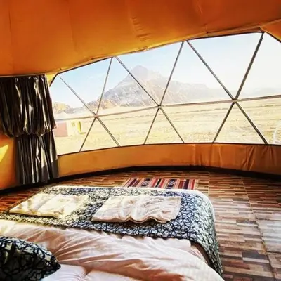 a bed in a room with a large window at Wade rum natural in Wadi Rum