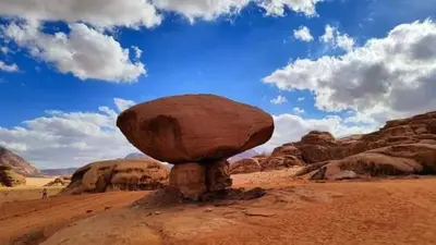 a large rock sitting on top of a desert at blueskyrum. in Wadi Rum