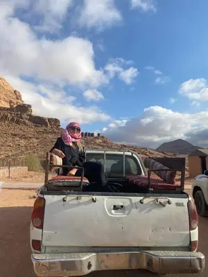 two people sitting in the back of a pick up truck at Yara camp in Wadi Rum