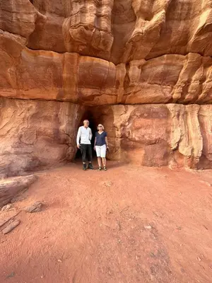two people standing in a cave in the desert at Yara camp in Wadi Rum