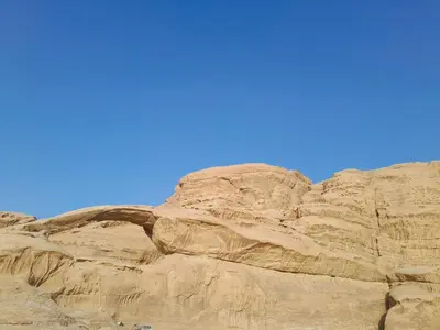 a rock formation in the desert with a blue sky at Desert Star of Wadi Rum in Wadi Rum