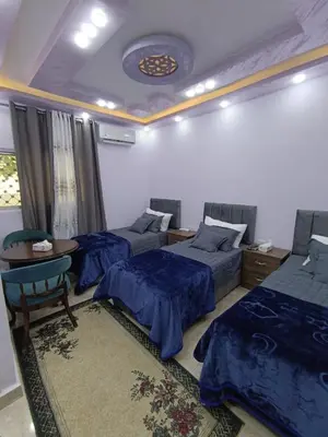 a bedroom with two beds and a table with a table at Petra downtown house in Wadi Musa