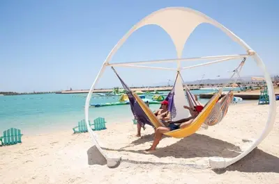 a couple of people sitting in hammocks on a beach at Ayla and chill Restricted to families and couples only in Aqaba