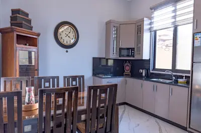 a kitchen with white cabinets and a clock on the wall at Adam's Luxury Villa DeadSea in Sowayma