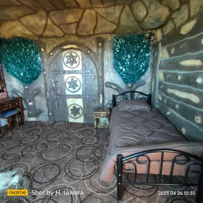 a bedroom with a bed in a stone house at Petra Dad Farm (PDF) in Umm Şawwānah