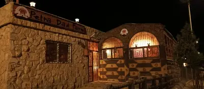 a stone building with two windows and a sign on it at Petra Dad Farm (PDF) in Umm Şawwānah