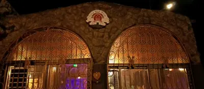 a building with two doors with a clock on it at Petra Dad Farm (PDF) in Umm Şawwānah
