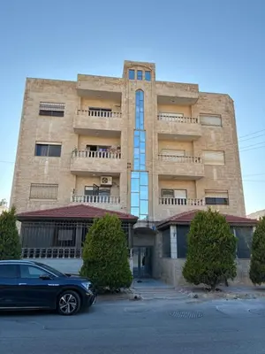 a black car parked in front of a building at Furnished Family Apartment in Dahyet Al-Rasheed in Amman