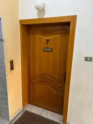a wooden door with a sign on top of it at Furnished Family Apartment in Dahyet Al-Rasheed in Amman