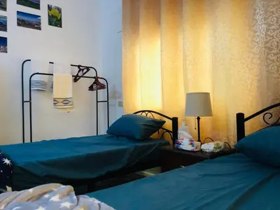 a room with two beds and a lamp on a table at Pasha's house in Balad al Manşūrah