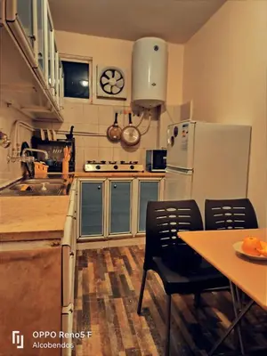 a kitchen with a refrigerator and a table with chairs at Plaza de petra in Wadi Musa