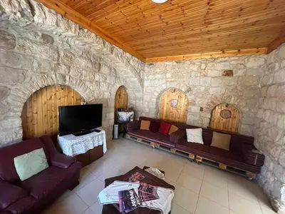 a living room with couches and a flat screen tv at Al Karak House in Kerak