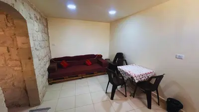 a room with a couch and a table and chairs at Al Karak House in Kerak