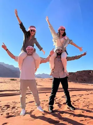 three women are standing on the desert at Hakon Matata Wadi Rum Jeep Tours Camp in Wadi Rum