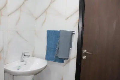 a bathroom with a white sink and a blue towel at Samarah Dead Sea Resort Apartment with Sea View FP4 Traveler Award 2025 Winner Thursday, Friday & Saturday Groups consisting solely of male guests are not permitted in Sowayma
