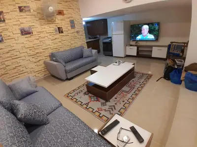 a living room with a couch and a tv at MK2 - One Bedroom Apartment in Amman