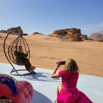 a woman taking a picture of a man in the desert at Wadi Rum The ARC camp in Wadi Rum