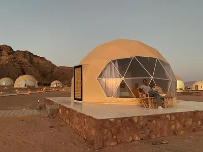 a man sitting in a dome tent in the desert at Wadi Rum The ARC camp in Wadi Rum