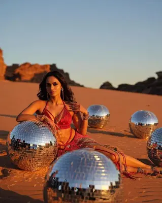 a woman sitting in the desert with disco balls at Wadi Rum Calma camp in Aqaba