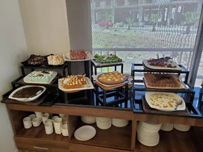 a shelf filled with different types of cakes and pastries at Petra Icon Hotel in Wadi Musa