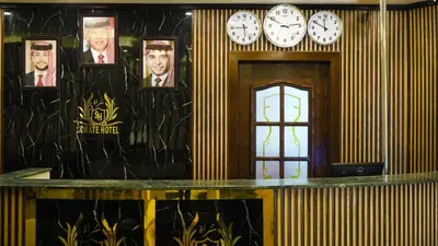 a lobby with clocks on the wall and a table at Sorate Hotel Apartment in Amman