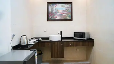 a kitchen with a counter with a microwave and a painting at Sorate Hotel Apartment in Amman