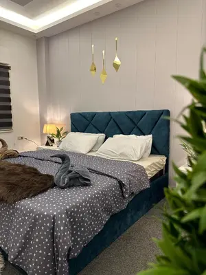 a bedroom with a blue bed with a blue head board at Jerash City View in Jerash