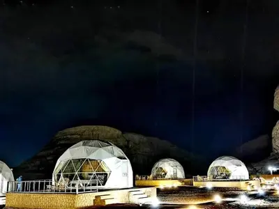 a group of domes in front of a rock formation at Echo Desert Camp in Wadi Rum