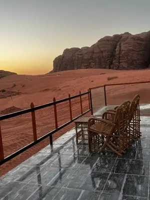 a table and chairs on top of a viewing deck in the desert at Echo Desert Camp in Wadi Rum