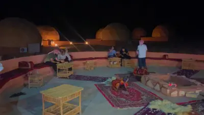 a group of people in a room with tables and chairs at Panorama bubble camp in Disah