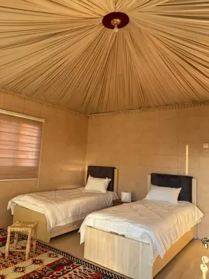 a bedroom with two beds and a ceiling at wadirumtours&camp in Wadi Rum