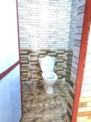 a bathroom with a toilet in a brick wall at wadirumtours&camp in Wadi Rum