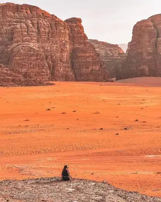 a person sitting in the middle of the desert at Wadi Rum Gulf camp in Aqaba
