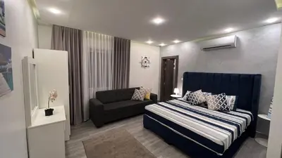 a small bedroom with a bed and a couch at Taj Villa 1 deadsea - Entire Villa with sea view in Sowayma