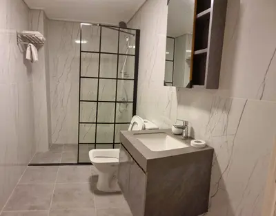 a bathroom with a toilet and a sink and a mirror at Byblos Deluxe in Aqaba