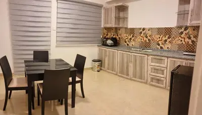 a kitchen with a black table and chairs and a sink at Byblos Deluxe in Aqaba