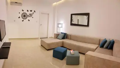 a living room with a couch and a tv at Byblos Deluxe in Aqaba