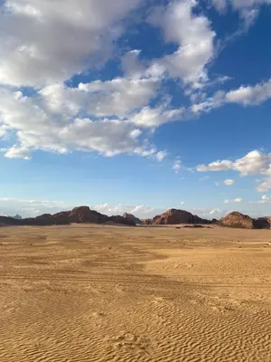 an empty desert with mountains in the background at Bedouin Secret Camp in Wadi Rum