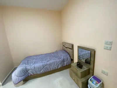 a bedroom with a bed and a mirror at Moon Apartments in Jerash