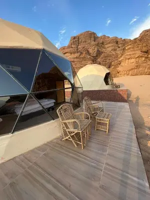 a group of chairs sitting on a deck with a tent at HILTON WADi RUM in Disah