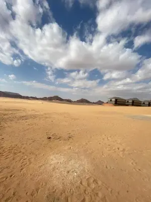 a desert with a building in the middle of it at Wadi Rum alsultan Camp in Wadi Rum