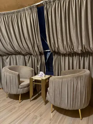 two chairs and a table in front of curtains at Wadi Rum alsultan Camp in Wadi Rum