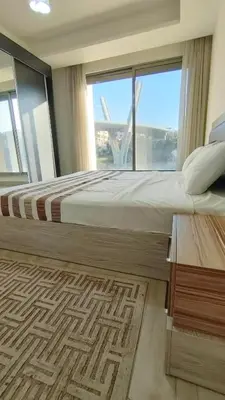a bedroom with a large bed and a large window at Bridge apartments in Amman
