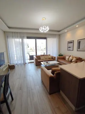 a large living room with couches and a table at Bridge apartments in Amman